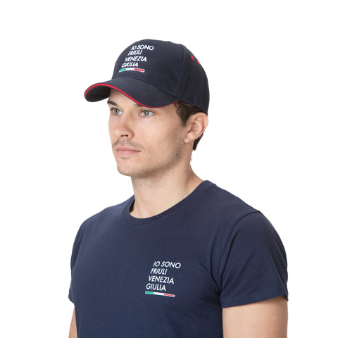 Cappellno blu indossato con logo IO SONO FRIULI VENEZIA GIULIA ricamato e bandiera italiana su sfondo bianco