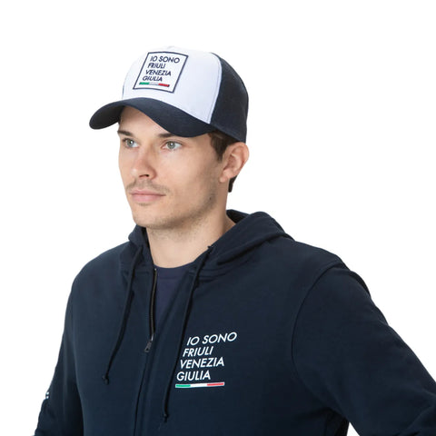 Cappello bianco e blu indossato con logo Io Sono Friuli Venezia Giulia e felpa coordinata.