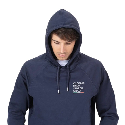 Felpa blu con logo piccolo Io Sono Friuli Venezia Giulia indossata da un ragazzo con cappuccio su sfondo bianco vista frontale