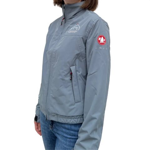 Giacca Waikato grigia impermeabile senza cappuccio con logo Barcolana indossata da una donna su sfondo bianco vista laterale