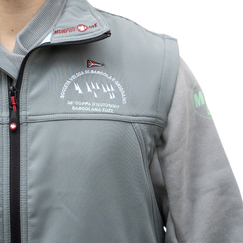 Dettaglio del gilet tecnico grigio con zip nera e logo Barcolana